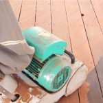 Sanding the deck with power sander